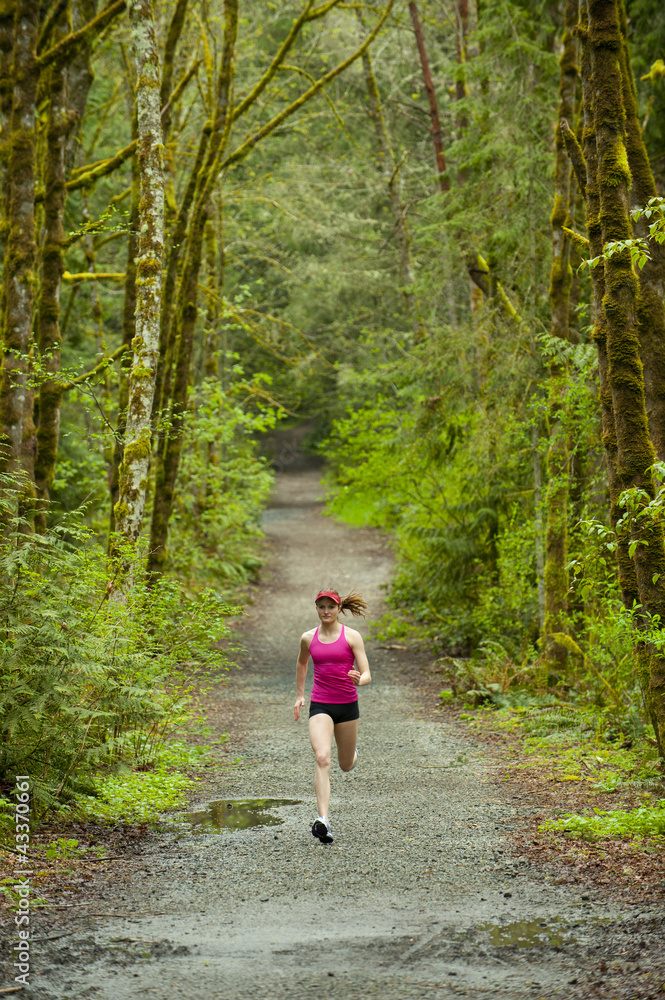 Mixed race woman running on remote path Mixed race woman running on remote path