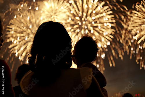 Silhouette of mother and daughter watching fireworks
