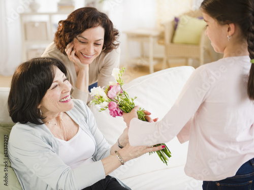 Granddaughter giving grandmother bouquet of flowers photo