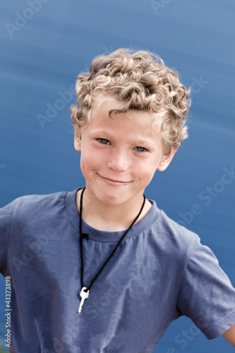 Portrait of the curly boy with a key on a neck