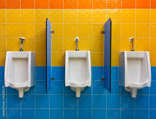 Urinals on colorful wall in public toilet
