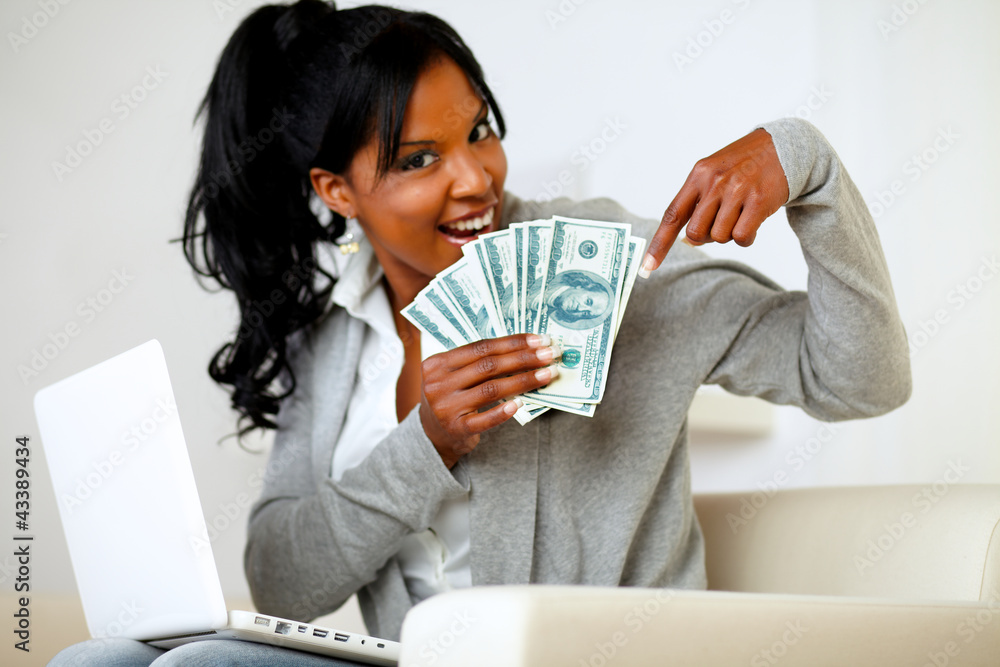 Happy young woman pointing plenty of cash money Happy young woman pointing plenty of cash money