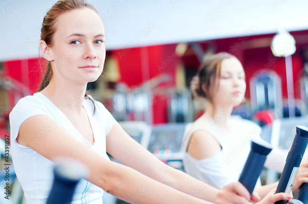 Two young sporty women run on machine Two young sporty women run on machine