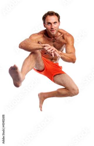 Young muscular man jumping against white