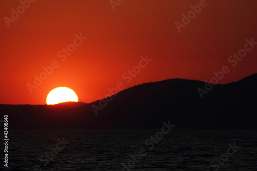 glowing orange red sunset or sunrise over hills and mountains