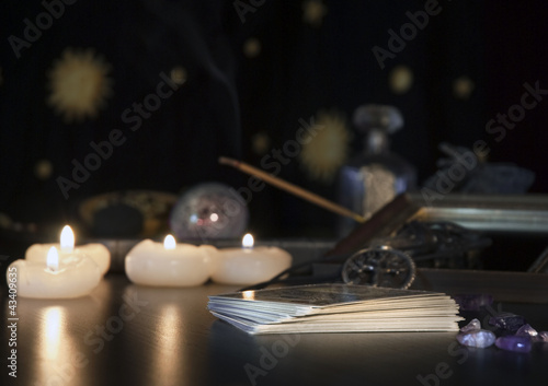 Esoterik allgemein - Tarotkarten, Räucherstäbchen und Kerzen vor Astrologiehintergrund