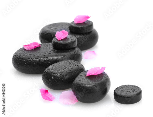 Spa stones with drops and pink petals isolated on white.