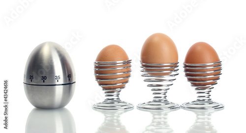 egg timer and egg in metal stand isolated on white