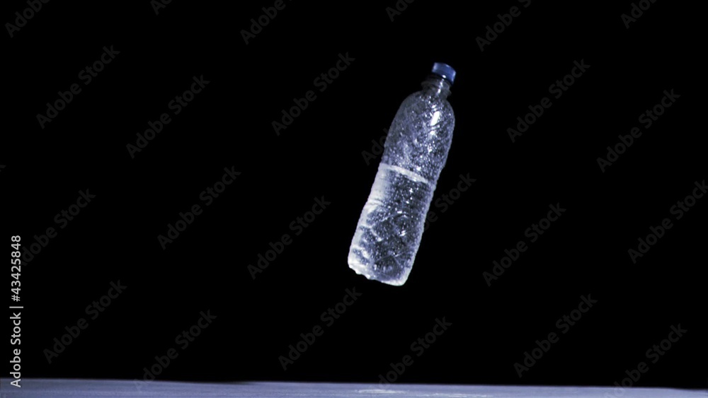 Bottle falling in super slow motion while filled with water Bottle falling in super slow motion while filled with water