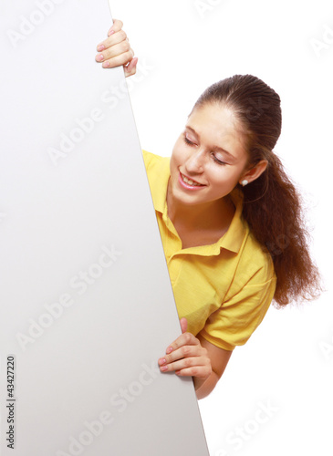 Portrait of a young girl holding a blank card deside her photo