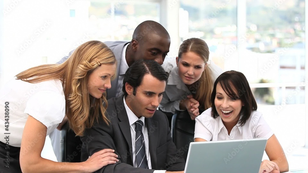 Happy business team looking at a computer Happy business team looking at a computer