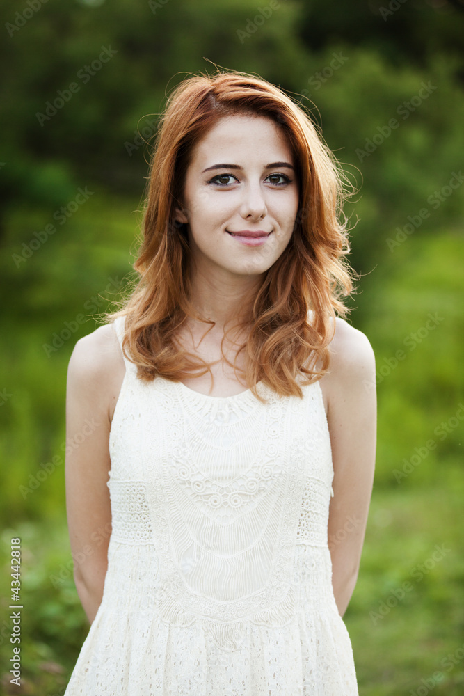 Redhead girl at green grass at village outdoor. Redhead girl at green grass at village outdoor.