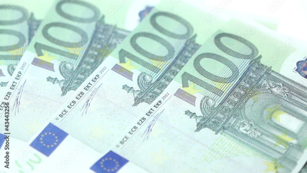 Hundred euro bills displayed by a hand on a table Hundred euro bills displayed by a hand on a table
