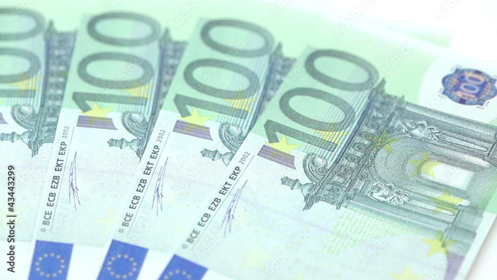 Hundred euro bills placed by a hand on a table Hundred euro bills placed by a hand on a table