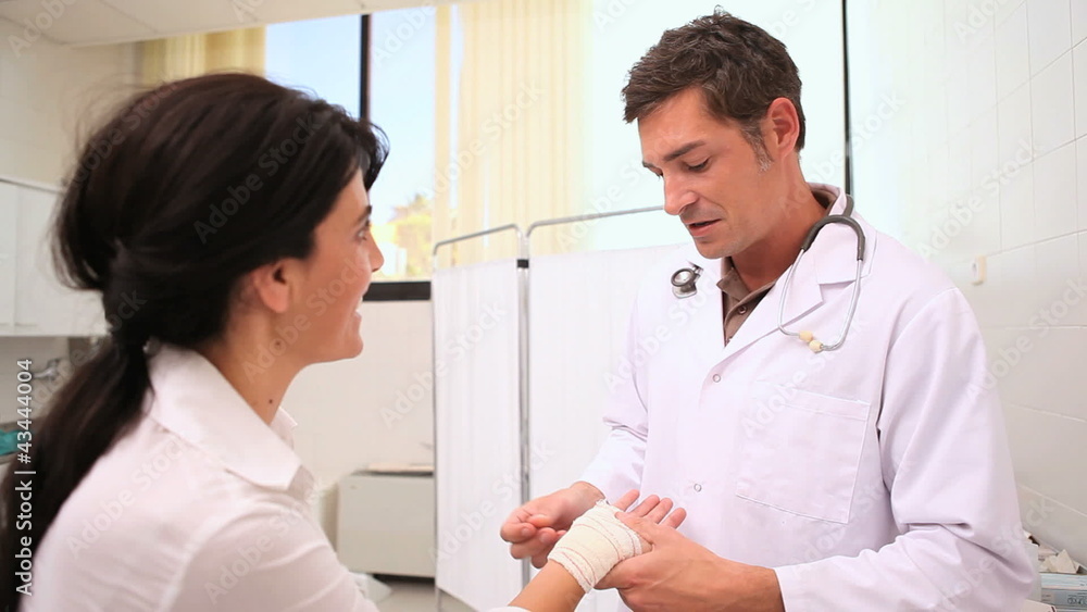 Doctor bandaging patient wrist Doctor bandaging patient wrist