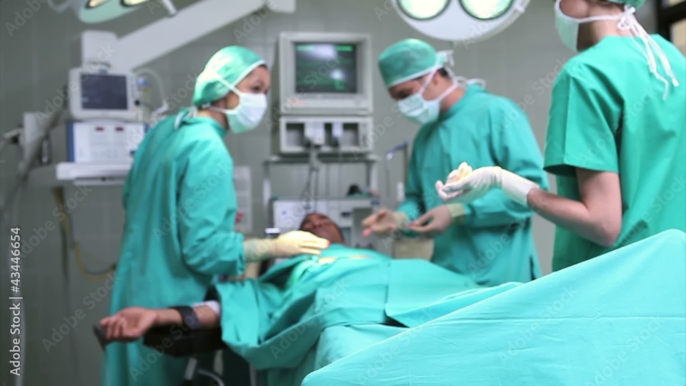 Doctors working on patient with tensiometer Doctors working on patient with tensiometer