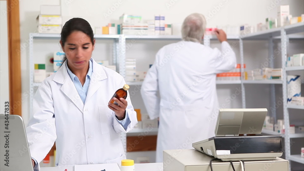 Female pharmacist holding a drug box while smiling Female pharmacist holding a drug box while smiling