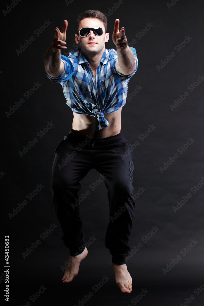 Young man jumping isolated black background Young man jumping isolated black background