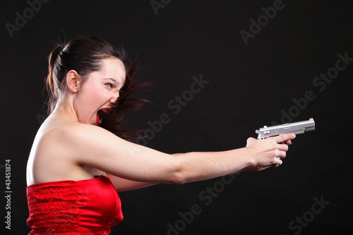 Sexy young woman - gun on black background