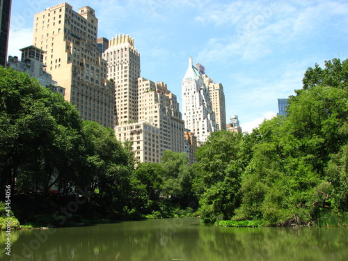 Skyscrapers of Manhattan from Central Park with Lake and Trees i