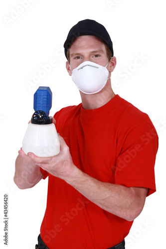 Man in a mask with a paintsprayer photo