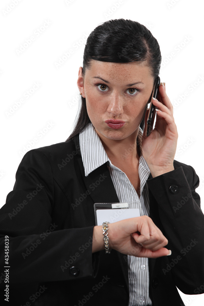 woman talking on her cell and looking at her watch woman talking on her cell and looking at her watch