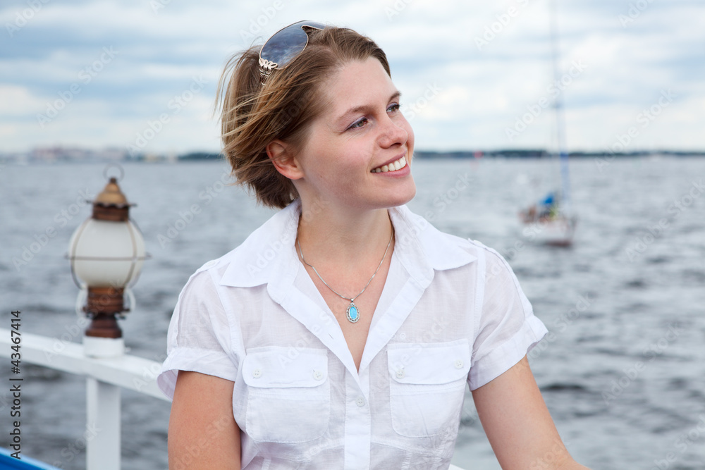 Girl in a white shirt on board the yacht looking away
