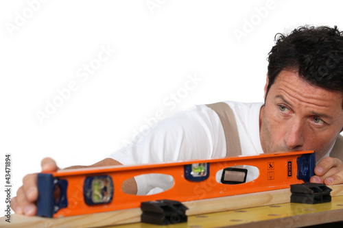 Mason measuring plank of wood photo