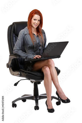 redhead woman with laptop sitting on chair