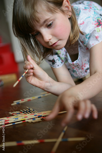 Photography A little girl playing pick-up sticks