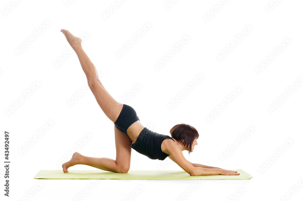 A young and sporty brunette woman doing a stretching exercise