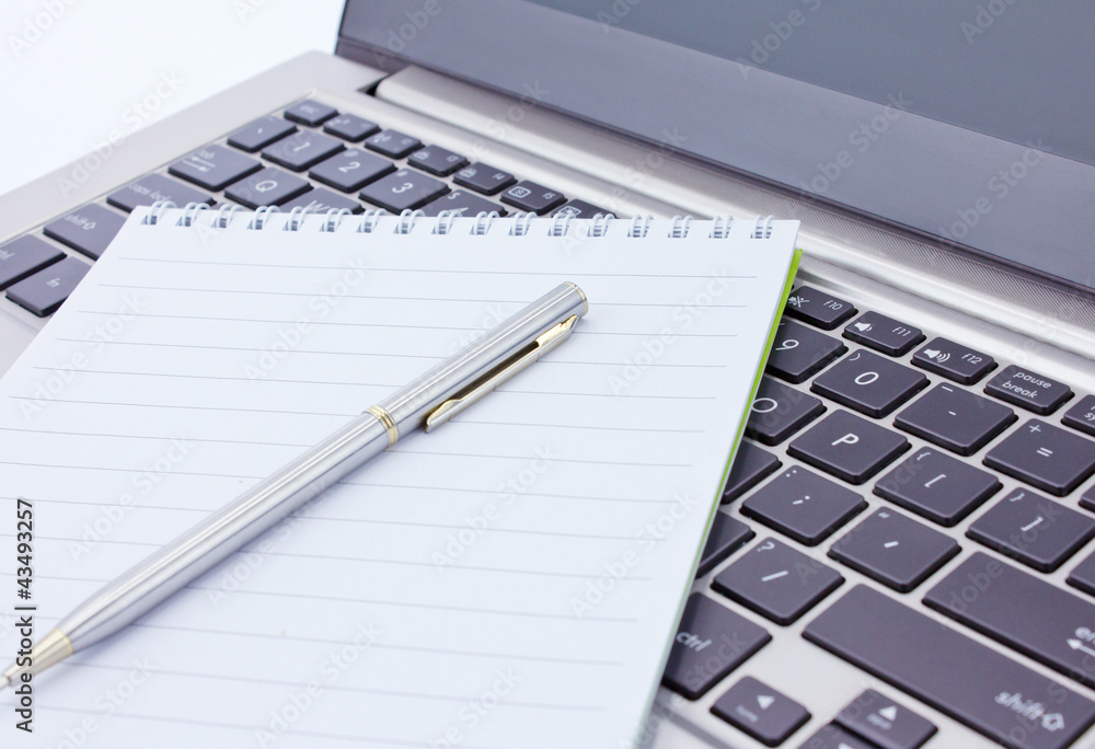 notebook and pen lie on the keyboard notebook and pen lie on the keyboard