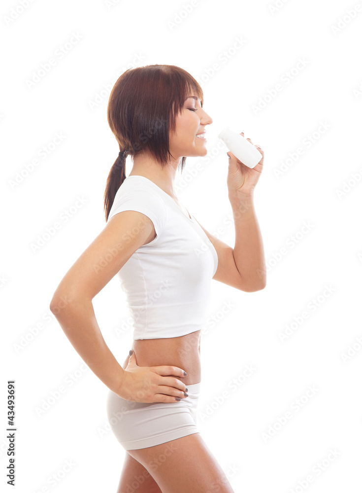 A young brunette woman in white sporty clothes holding a bottle A young brunette woman in white sporty clothes holding a bottle
