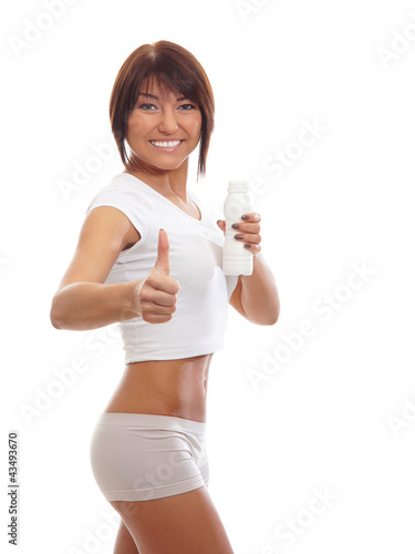 A young brunette woman in white sporty clohes holding a bottle © Acronym
