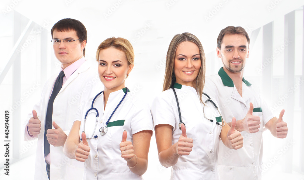 A team of young Caucasian medical workers in white clothes A team of young Caucasian medical workers in white clothes