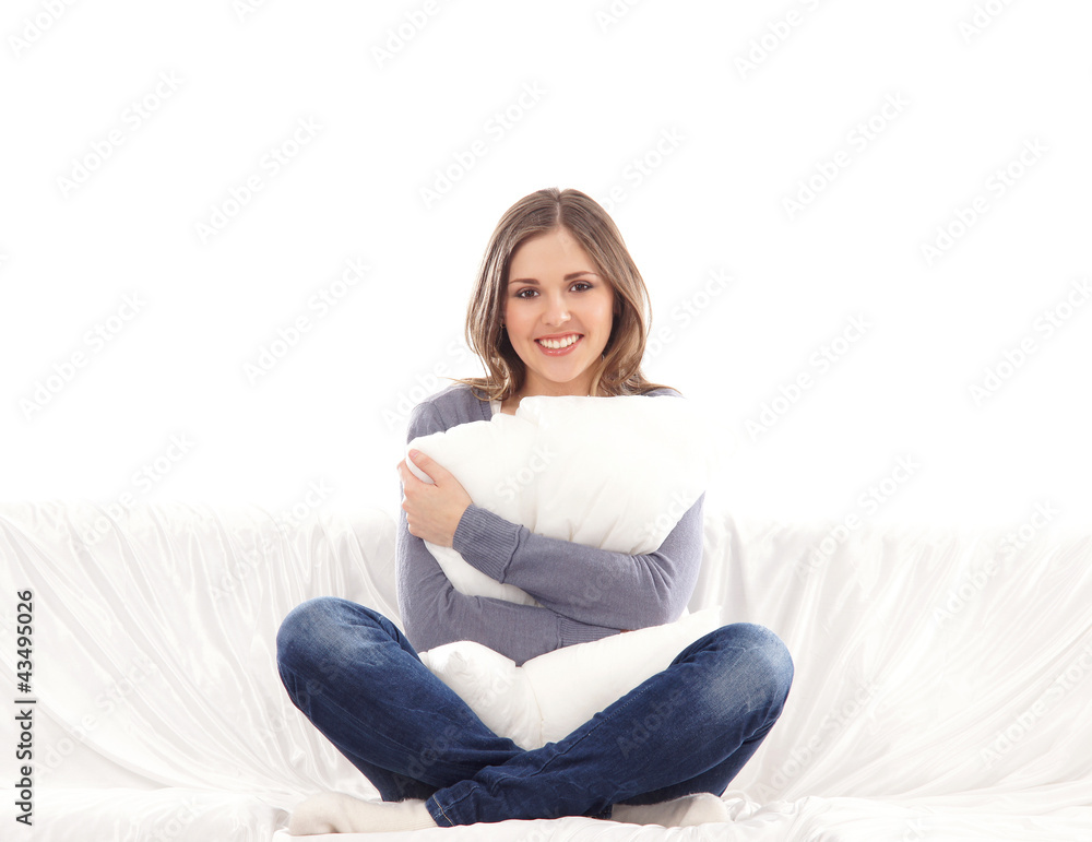 A young brunette Caucasian woman relaxing on a whie sofa