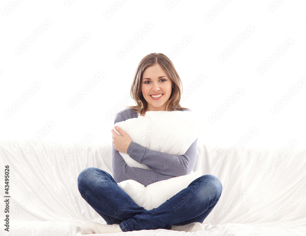 A young brunette Caucasian woman relaxing on a whie sofa A young brunette Caucasian woman relaxing on a whie sofa