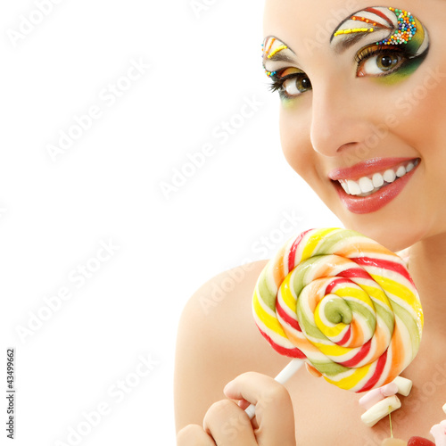 woman licks candy with beautiful make-up photo