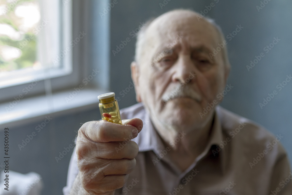 old man holding pills old man holding pills