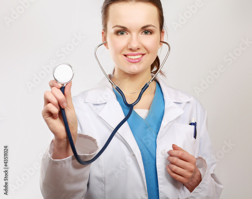 A female doctor with a stethoscope listening