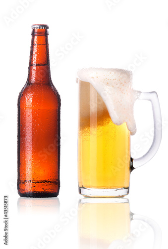 Frosty glass of light beer with bottle isolated