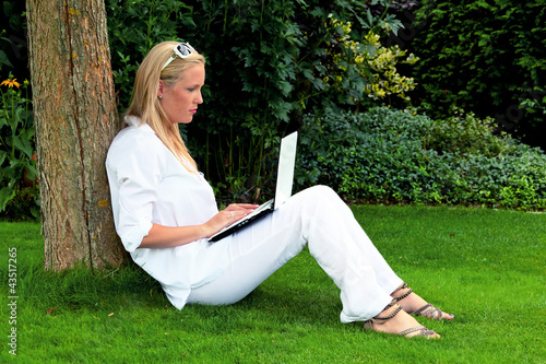 Frau mit Laptop Computer im Garten photo