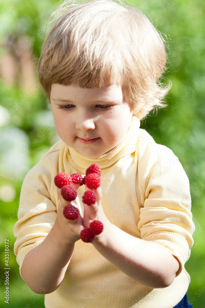 Cute little girl with raspberries on her fingers Cute little girl with raspberries on her fingers