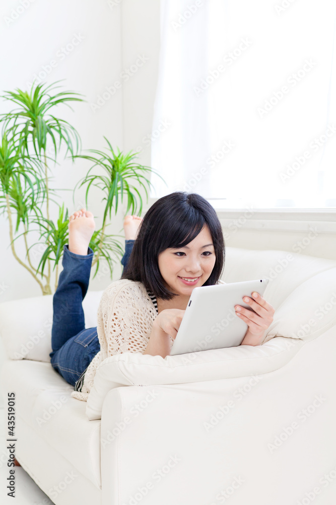a young asian woman using tablet computer