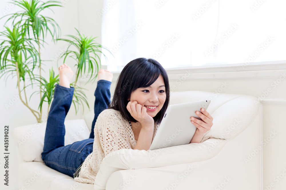 a young asian woman using tablet computer a young asian woman using tablet computer