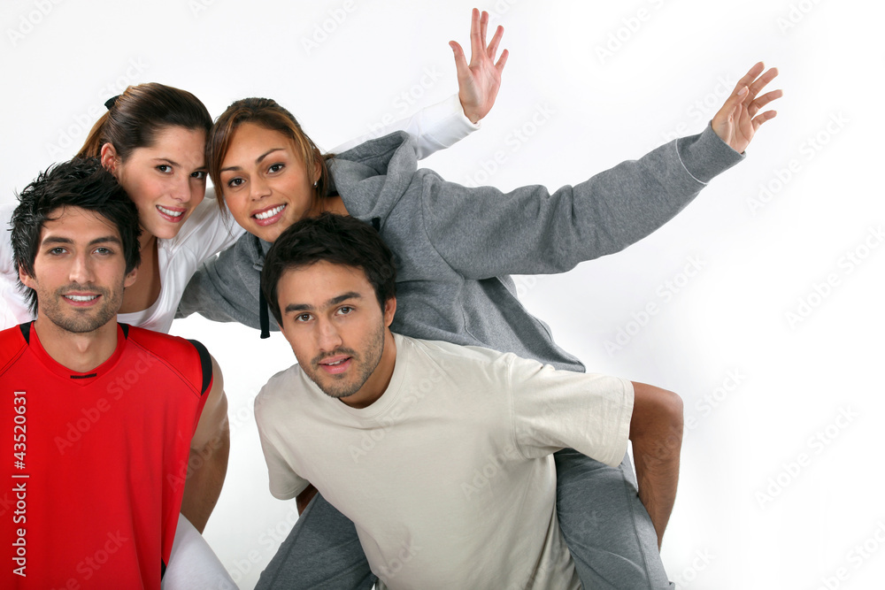 Young men giving their girlfriends piggy-back rides Young men giving their girlfriends piggy-back rides