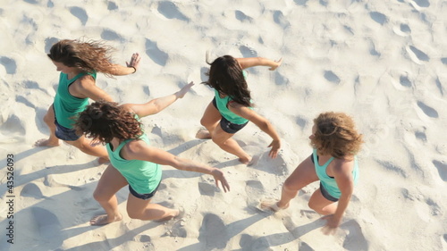 Above view of pretty girls dancing on the sand
