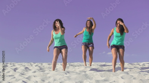 Beautiful women dancing on the sand together
