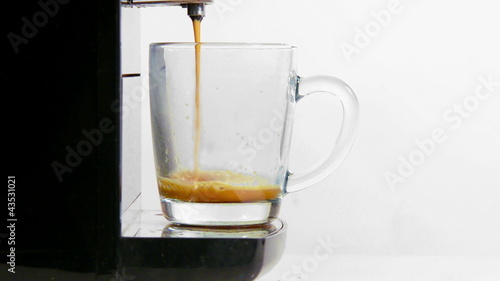 coffee maker pours coffee into a cup. close-up