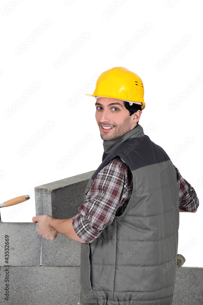 A mason building a wall. A mason building a wall.
